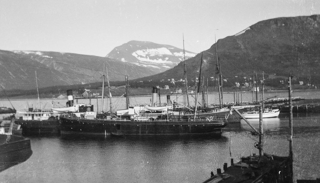Historisk svart-hvitt-foto av dampskip og seilskuter i indre havn